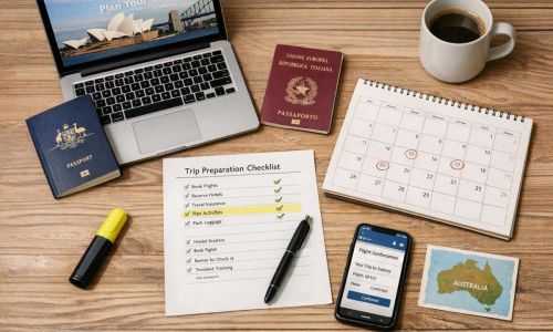Home 7 Viaggiatore organizza documenti viaggio Australia su scrivania con passaporto, laptop, calendario e checklist stampata